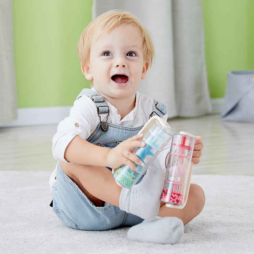 Dziecko bawi się drewnianą deszczownicą Classic World z kolorowymi kuleczkami – sensoryczna zabawka muzyczna Montessori