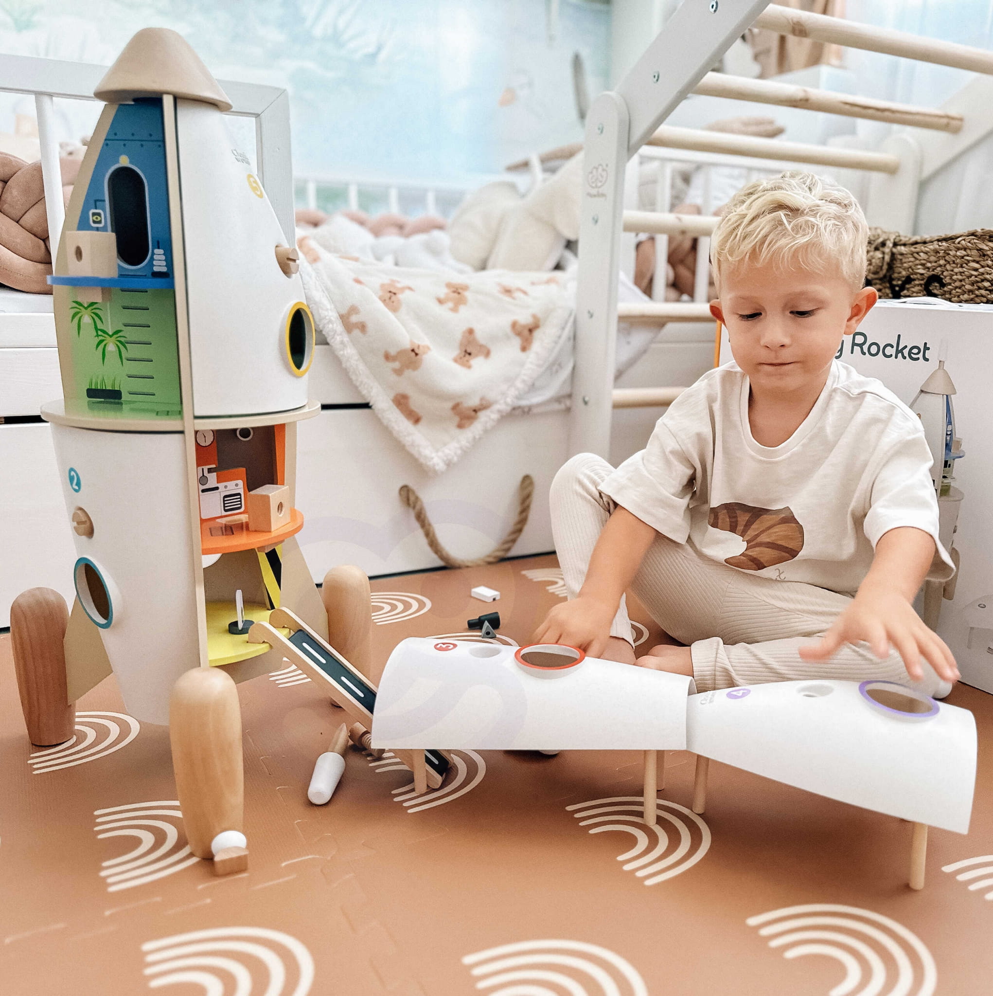 Dziecko bawiące się drewnianą rakietą kosmiczną XL - domek dla astronautów rozwijający kreatywność i wyobraźnię